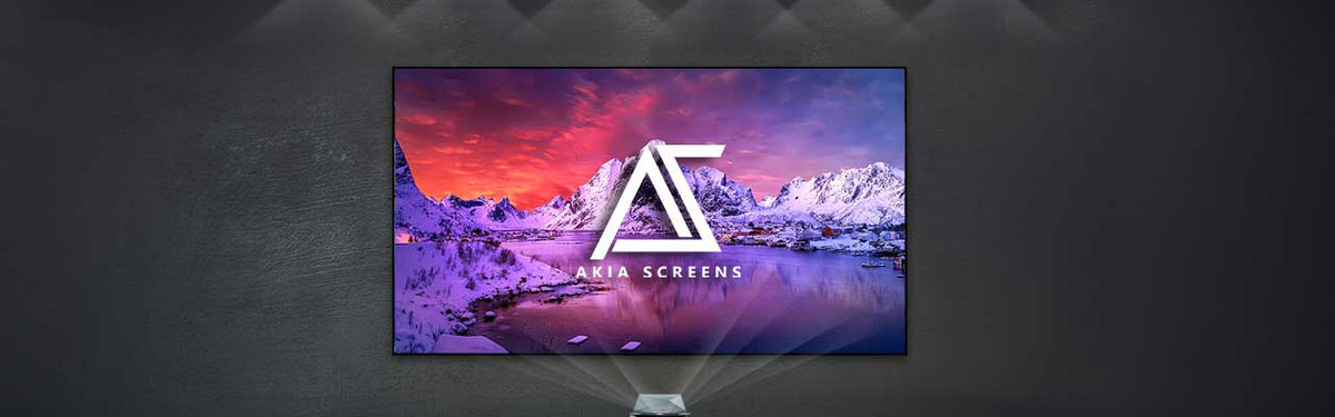 A large flat-screen display mounted on a dark wall, showing a colorful mountain landscape with a large white 'AS' logo and 'ARIA SCREENS' text on the screen. The display is centered against a dark gray wall with subtle lighting and shadow effects.